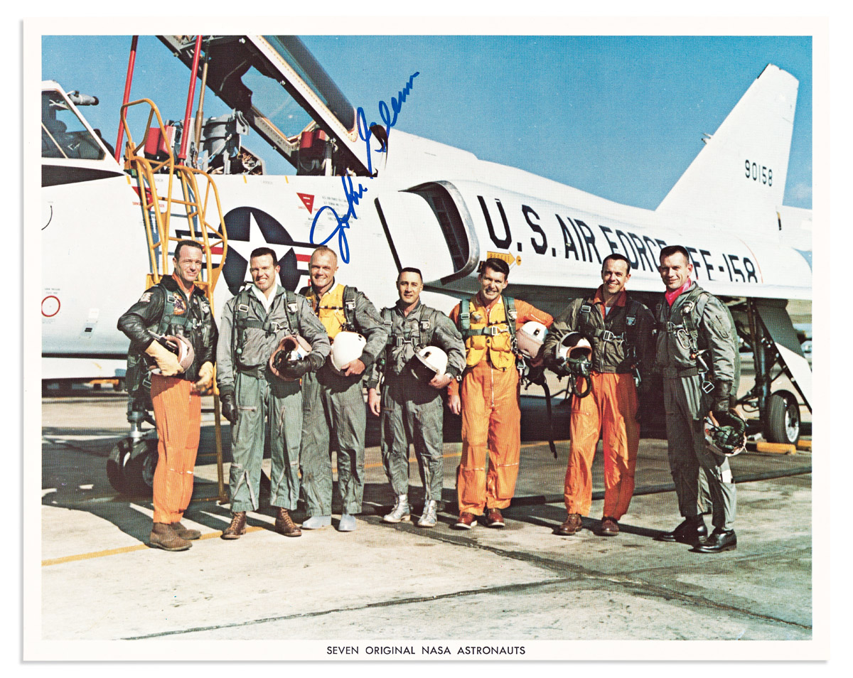 (ASTRONAUTS.) GLENN, JOHN. Color Photograph Signed, full-length group portrait by NASA, showing the Mercury Seven standing in front of